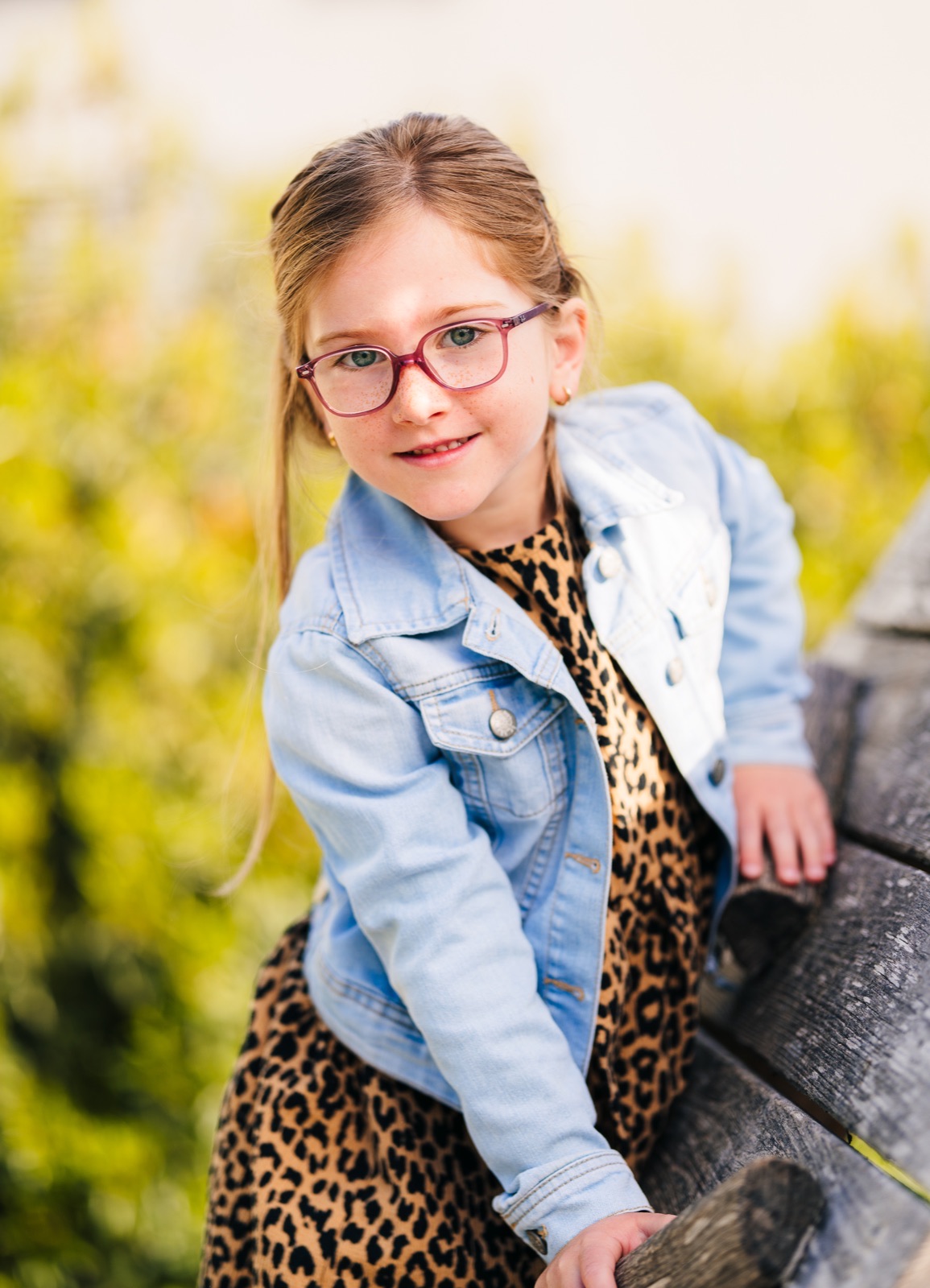 Natürliches Kinderporträt eines Mädchens mit Brille im Freien
